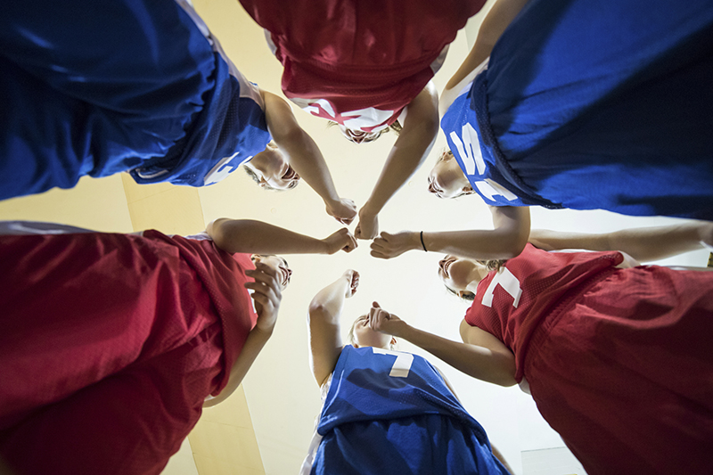 Diverse teenage girl athletes cheering after their team huddle Sports Injuries in Stuart, FL
