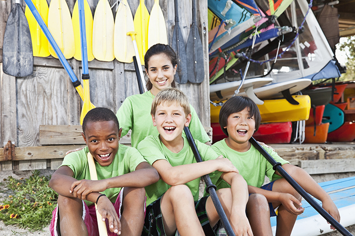 Camp counselor with boys at water sports equipment shack sports injury prevention